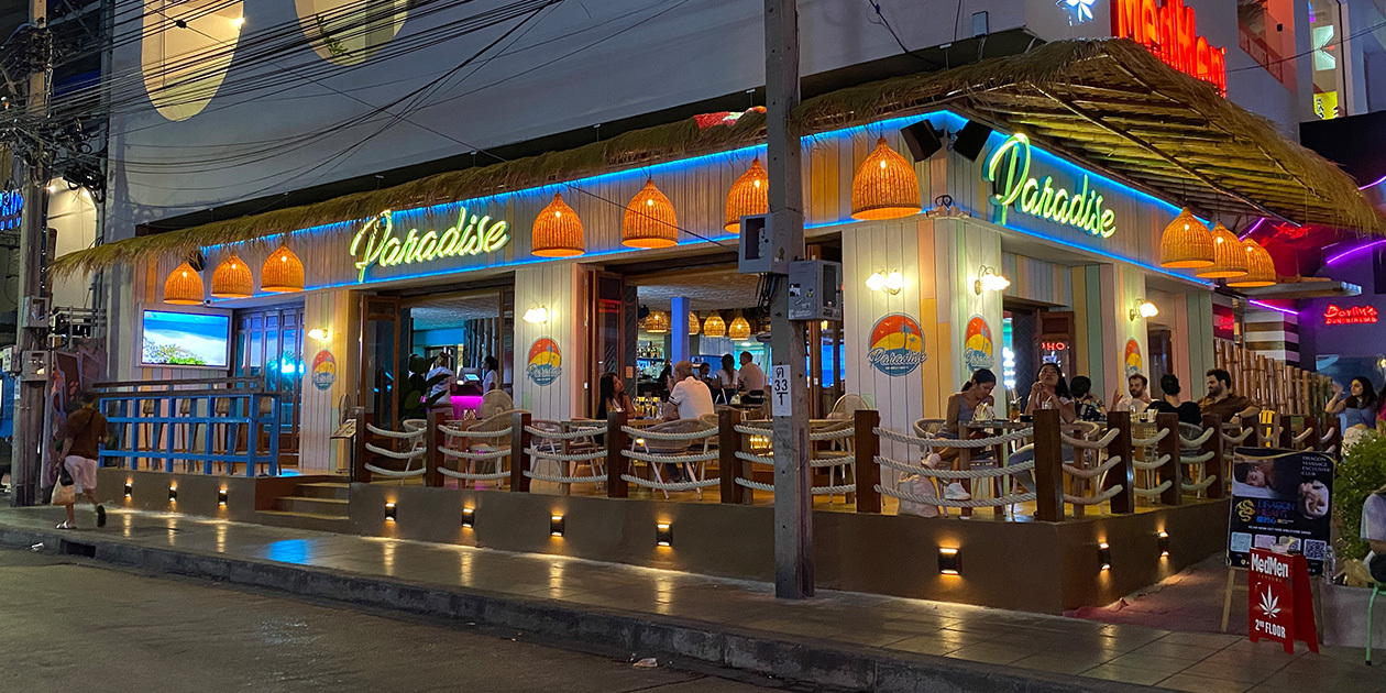 Paradise Soi 11 street terrace at night, under a thatched roof on Sukhumvit Soi 11