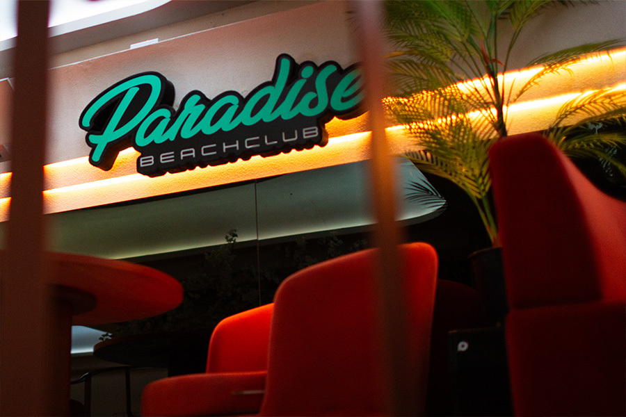 Lounge seating under the neon Paradise sign on the upstairs floor